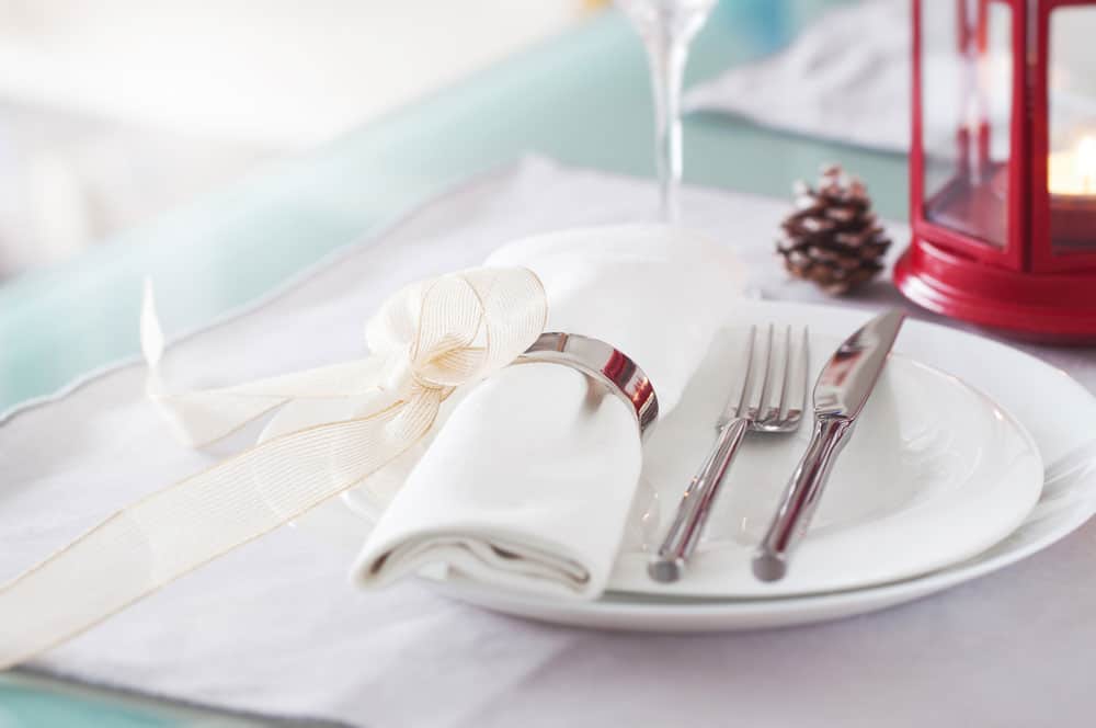 elegant-decorated-christmas-table-setting-with-modern-cutlery-napkin-bow-christmas-decorations-christmas-menu-concept-closeup-horizontal