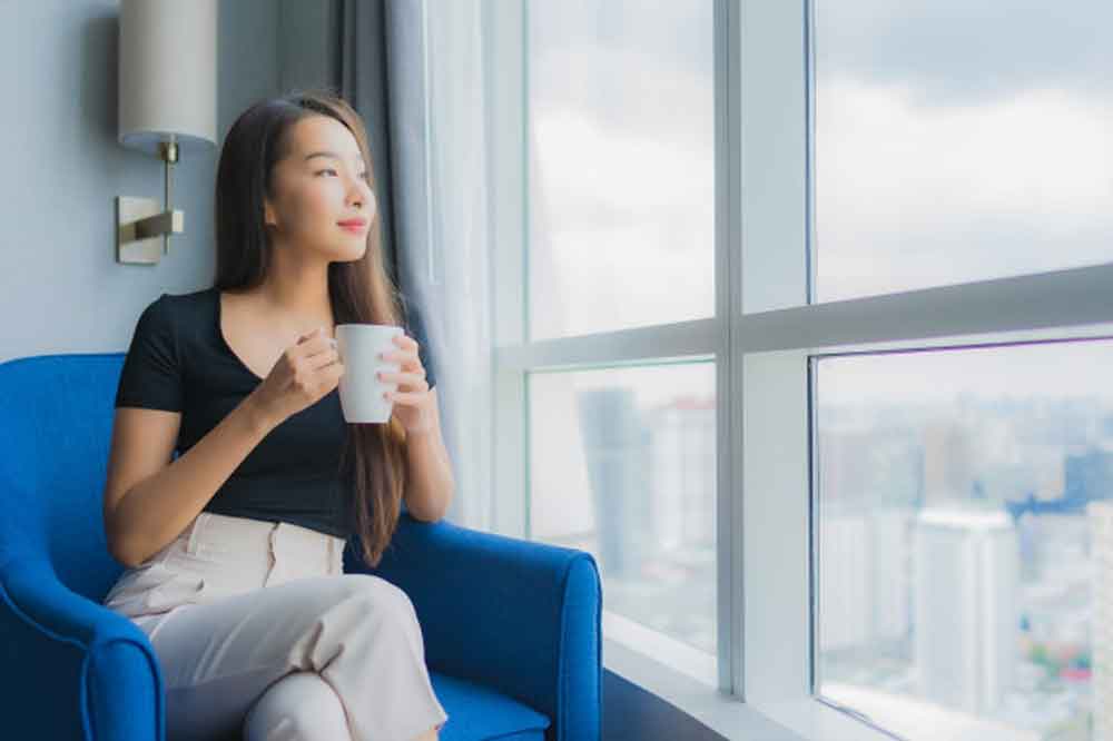 relaxed woman with mug staring out window