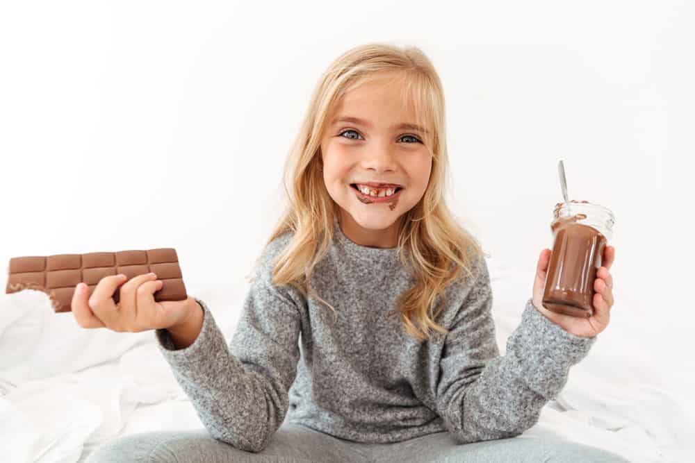 cute-funny-girl-holding-chocolate-bar-showing-her-dirty-teeth