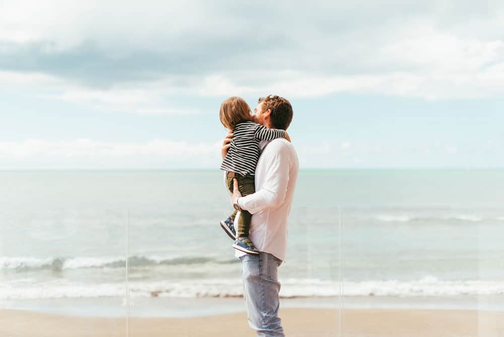 father-holding-toddler-son-seashore