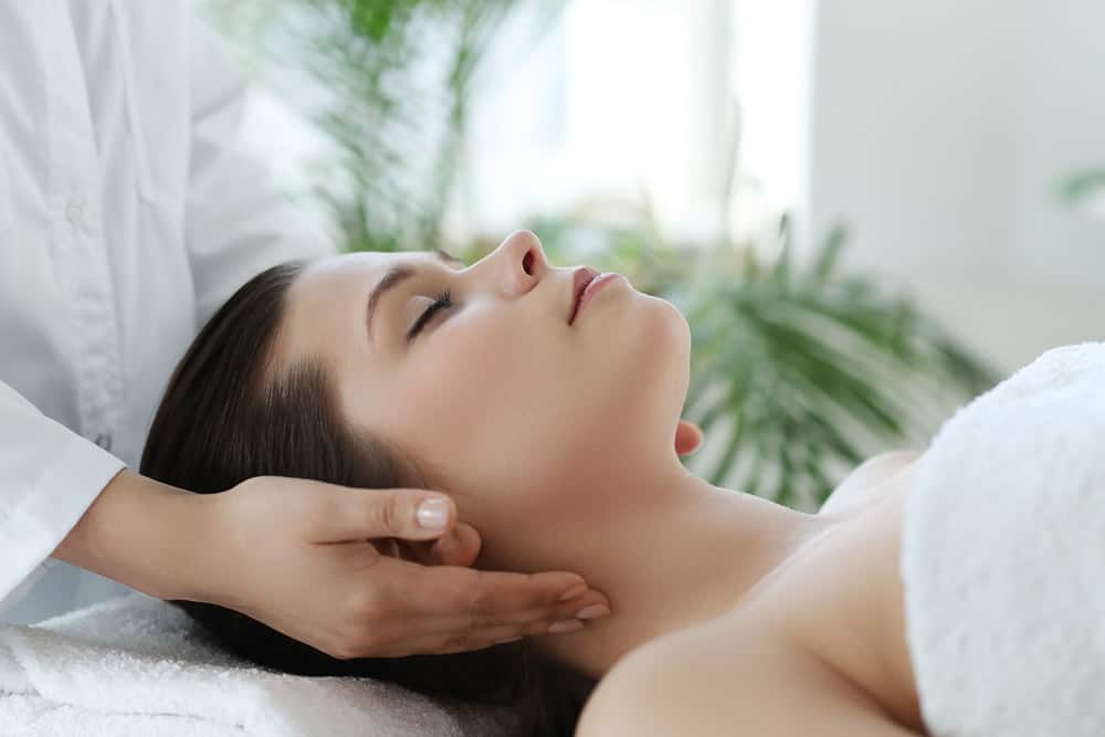 lying-woman-receiving-massage-craniosacral-therapy