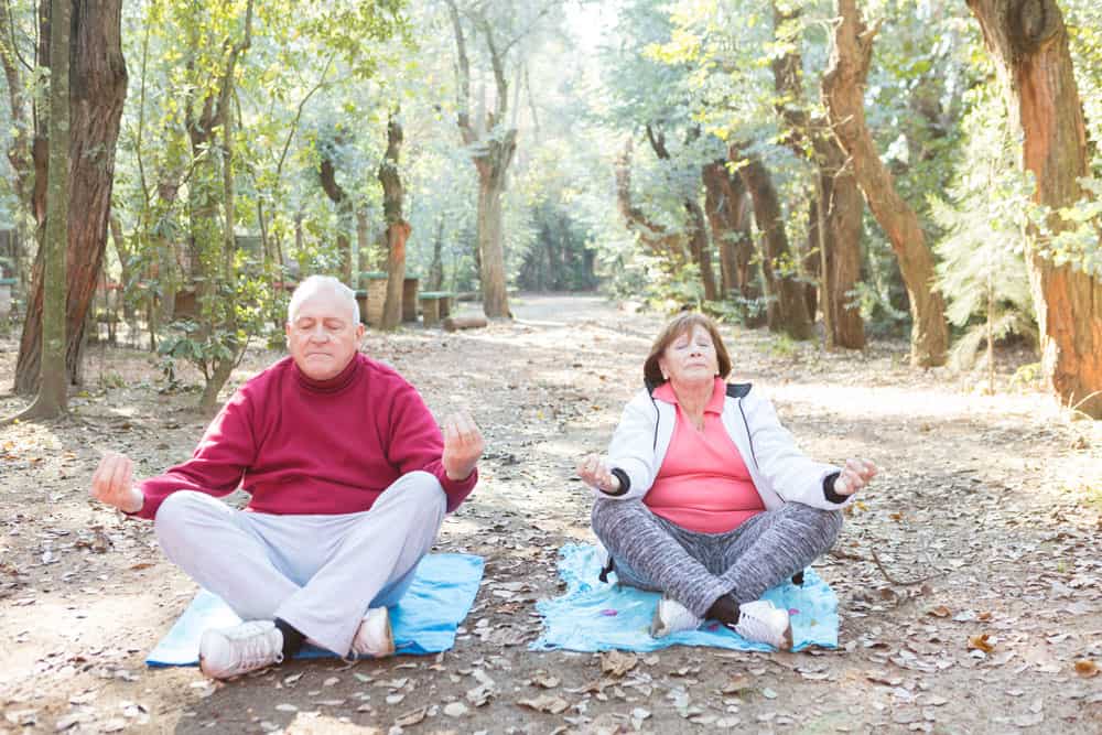 senior-couple-with-crossed-legs-during-meditation