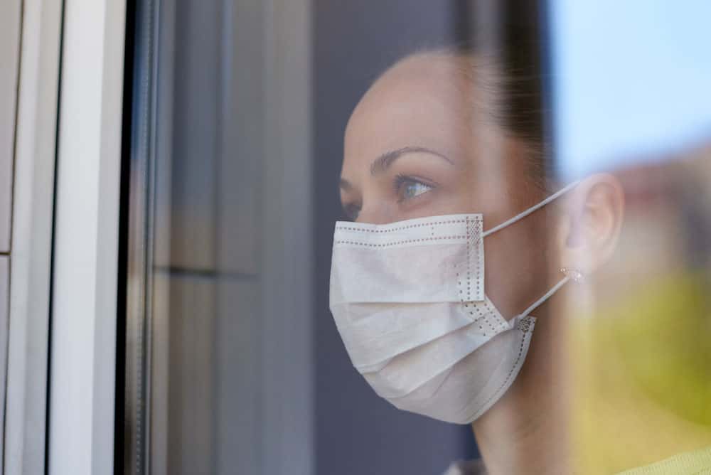 young-sad-woman-medical-mask-quarantine-looks-out-window