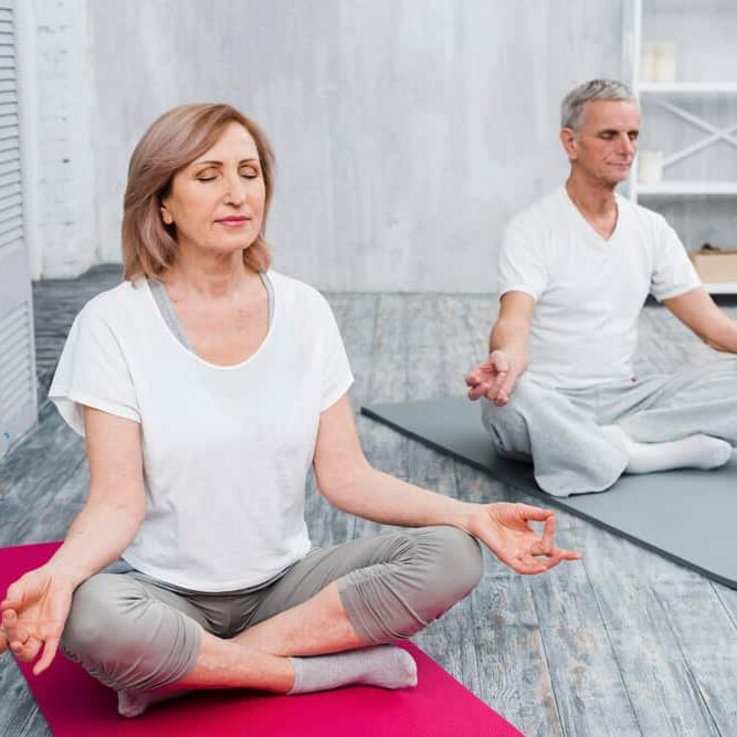senior-couple-performing-meditation-exercise-mat-home
