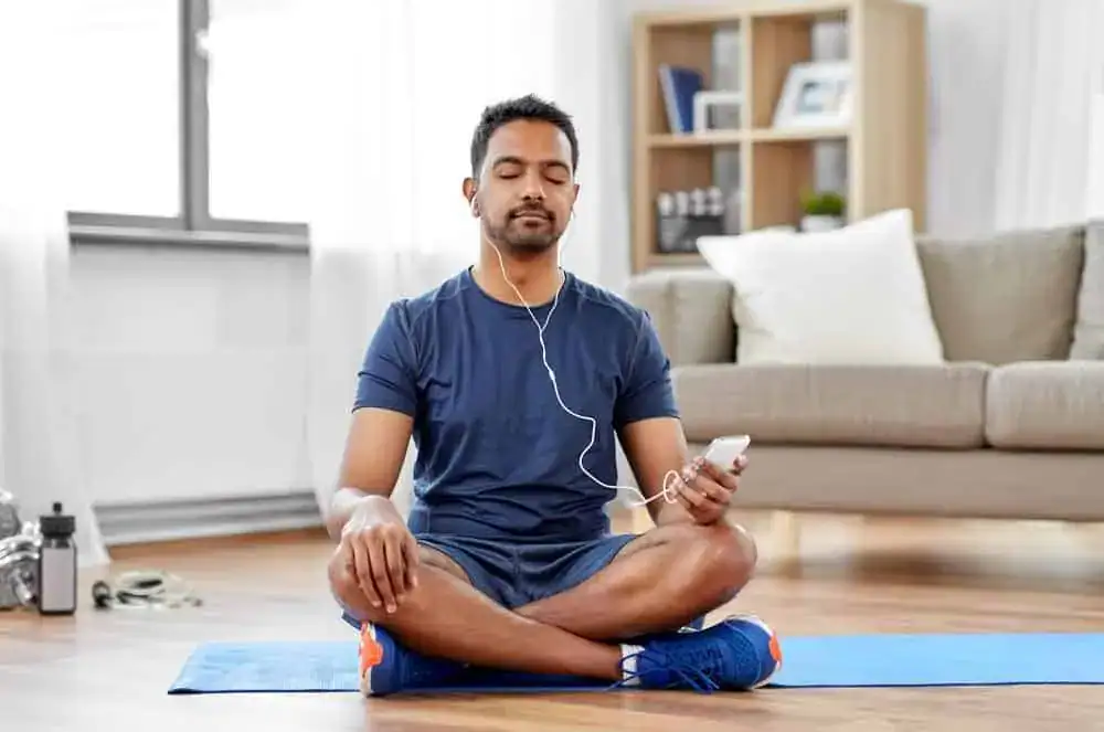 man meditating in living room meditating in living room