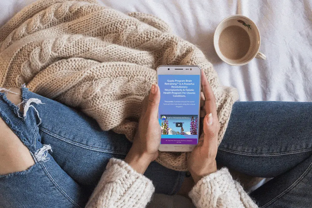 woman-holding-phone-on-bed woman-holding-phone-on-bed