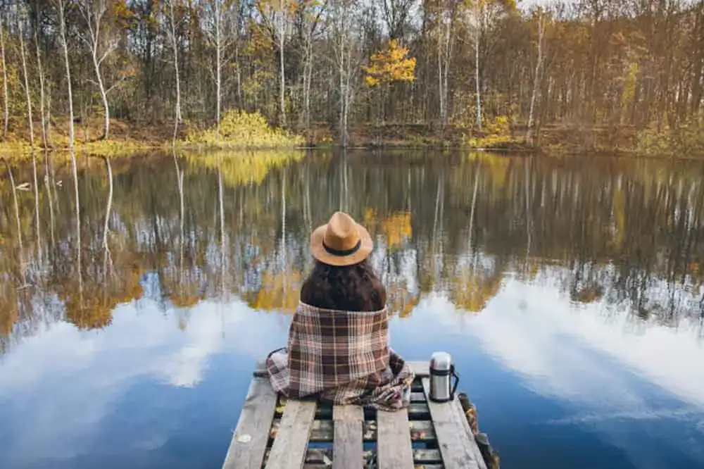 woman sitting on wooden dock woman sitting on wooden doc