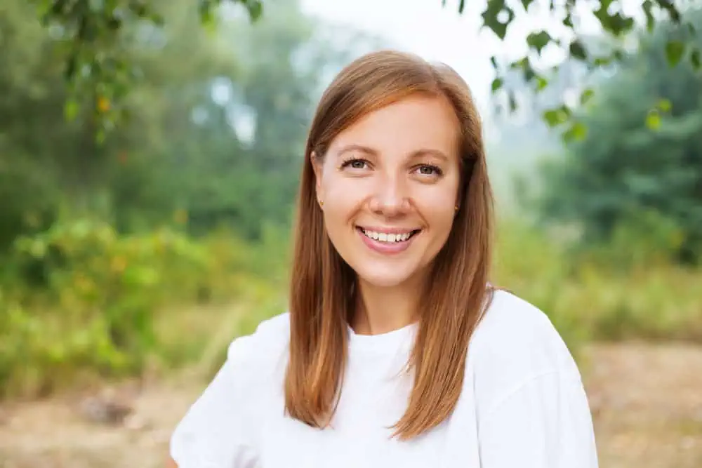 junge-schöne-lächelnde-Frau-im-Sommerpark