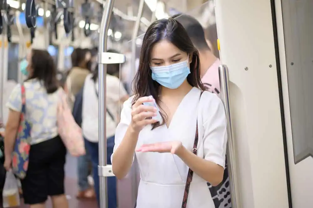 young-woman-wearing-protective-mask-subway-is-using-alcohol-wash-hands-travel-covid-19-pandemic-safety-travels-social-distancing-protocol young-woman-wearing-protective-mask-subway-is-using-alcohol-wash-hands-travel-covid-19-pandemic-safety-travels-social-distancing-protocol